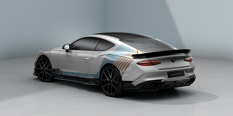 Bach Premium Cars GmbH Bentley Supersports rear three quarter in "Snowstorm" Design theme with Snow Quartz paint and Topaz blue and Camel brown paint stripes across the rear haunch.